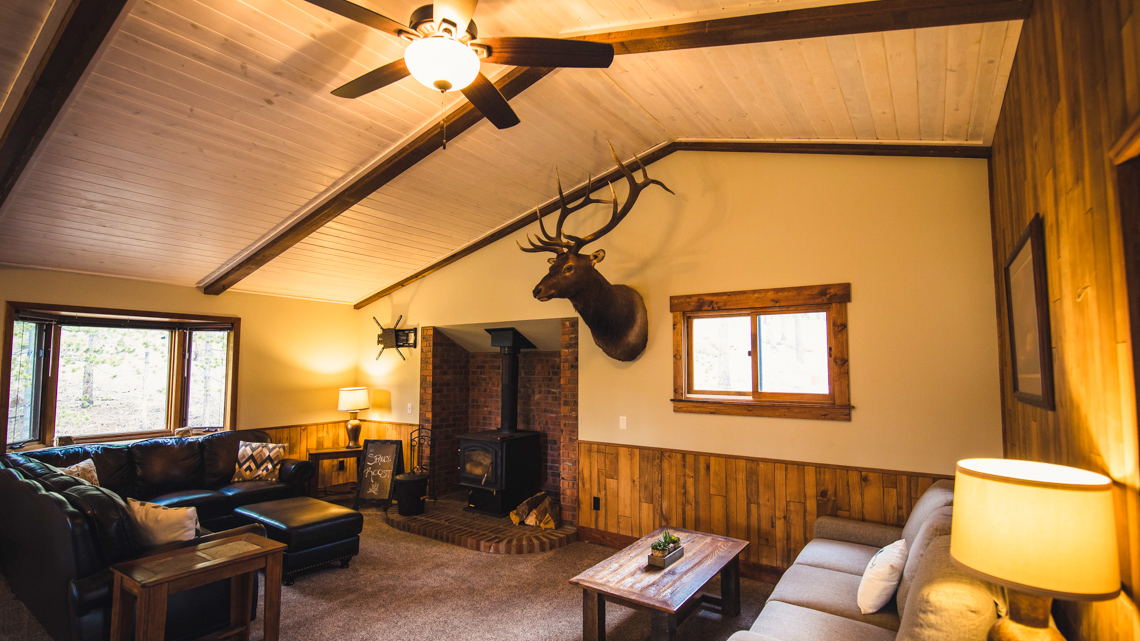 A cozy lobby with a fireplace, wood paneling, and comfortable seating.